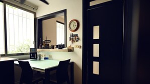 A dining area with a table and chairs, a microwave, a coffee maker, and a clock on the wall. - ROOM WITH PRIVATE BATHROOM, IN A HOUSE WITH SHARED AMENITIES AND A POOL (Palmira)