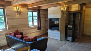 Ein gemütliches Zimmer mit einer Couch, einem Fernseher, einem Kamin und einem Essbereich.