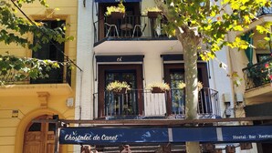 A cafe with outdoor seating, a sign reading "Chostalet de Canet," and a tree in the foreground.