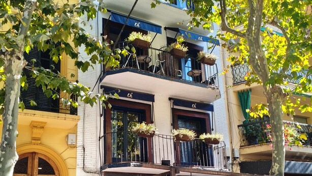 A café with outdoor seating, a wooden door, and a sign reading "l'hôtelet de Canet".