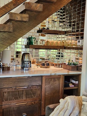 Eine Küche mit Holzschnitzereien, einer Kaffeemaschine und einem Glastrennschrank.