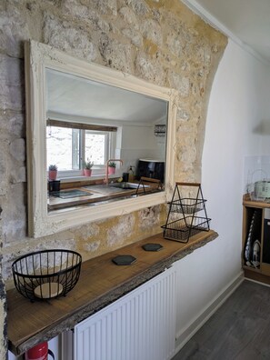 A kitchen with a stone wall, a wooden countertop, a sink, and a mirror. - Newly Renovated  Fisherman’s Cottage with Large Courtyard • Near Chesil Beach (PORTLAND)