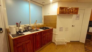 Una cocina con armarios de madera, un lavamanos, una estufa y una ventana.
