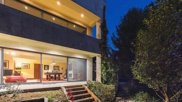 A modern two-story building with large windows, a visible dining area, and a staircase leading to the entrance. - Farm Paradise in Douro 10 People (Baiao)