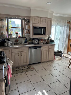 A kitchen with a microwave, dishwasher, and various kitchen items on the counter.
