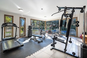 Une salle de sport équipée de tapis de course, de vélos elliptiques et de matériel de musculation.