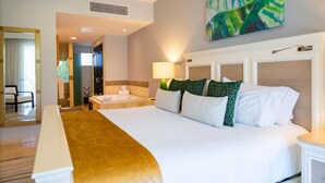 A hotel room with a large bed, a bathtub, a desk, and a chair.