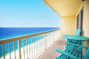 Ein Balkon mit Blick auf das Meer, einem Tisch und Stühlen.