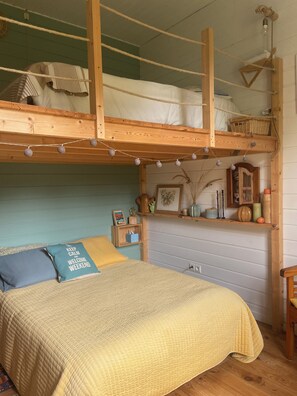 A bunk bed with a wooden headboard, a bedside table with a lamp, and a shelf with decorative items. - Typical single-storey Médoc house with outbuildings and swimming pool (Carcans)