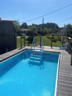 A rectangular swimming pool with a wooden deck and metal ladder. - Typical single-storey Médoc house with outbuildings and swimming pool (Carcans)