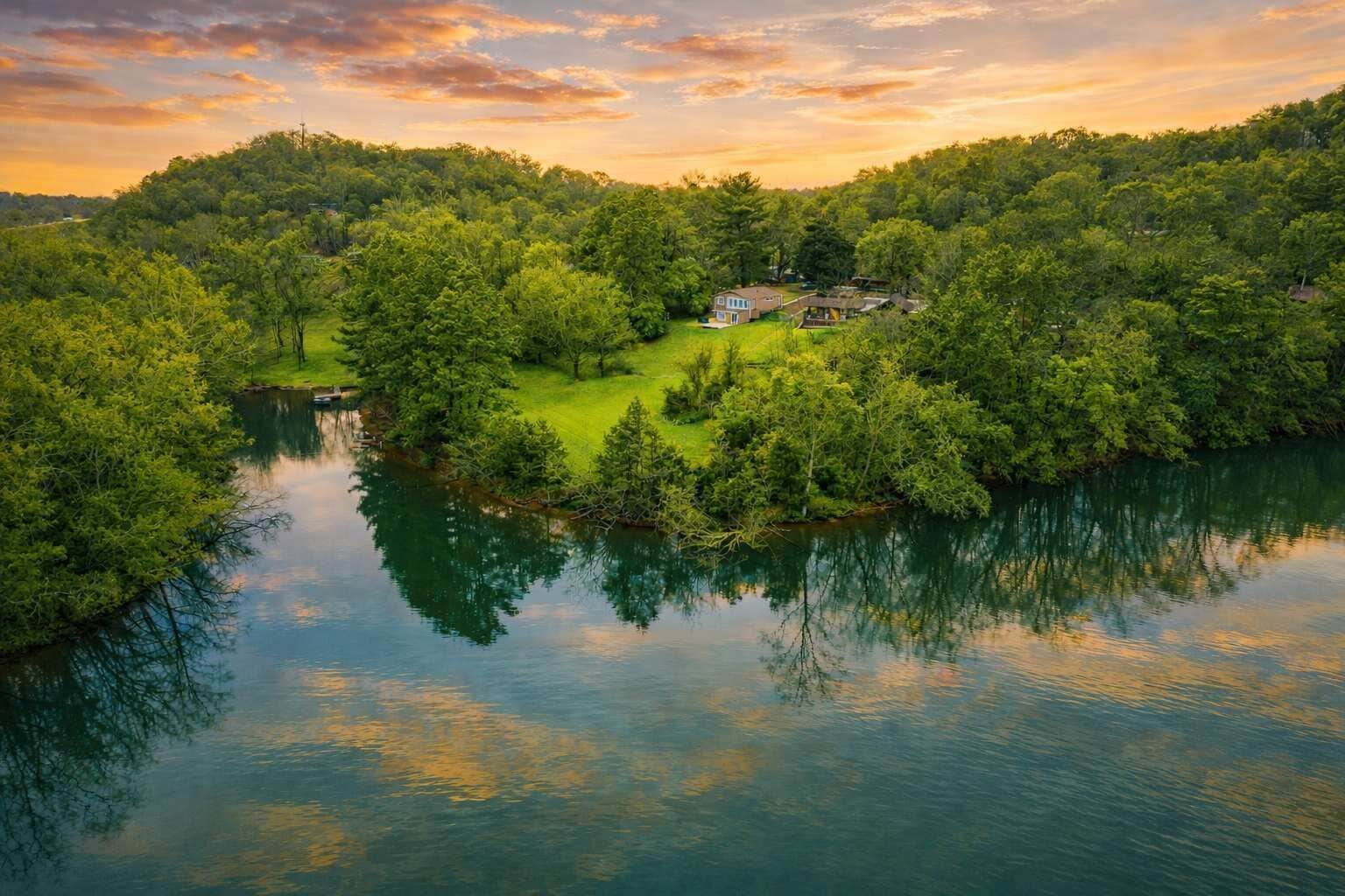 Aerial view of Fort Patrick Henry Lake, featuring a quiet shoreline, wooded surroundings, and peaceful water just steps from the property—an inviting setting to relax, explore, and enjoy the beauty of East Tennessee.