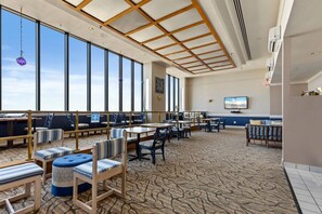 A spacious indoor area with high ceilings, large windows, and a patterned carpet. - Ocean Forest Plaza 912 (Myrtle Beach)