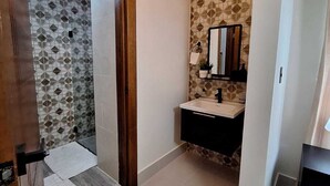 Ein Badezimmer mit Waschbecken, Spiegel und Wandfliesen mit Muster.