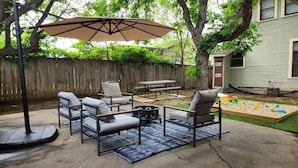Un patio al aire libre con un columpio, una mesa y sillas.