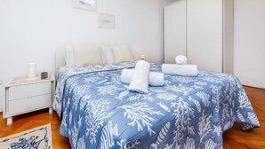 Ein Schlafzimmer mit einem Bett, einem weißen Nachttisch und einem großen Kleiderschrank.