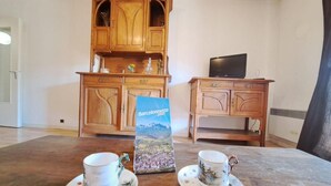 Una stanza con un armadietto di legno, una televisione e due tazze su un tavolo.