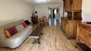 Un soggiorno con un divano, un tavolo da pranzo e mobili contenitori in legno.