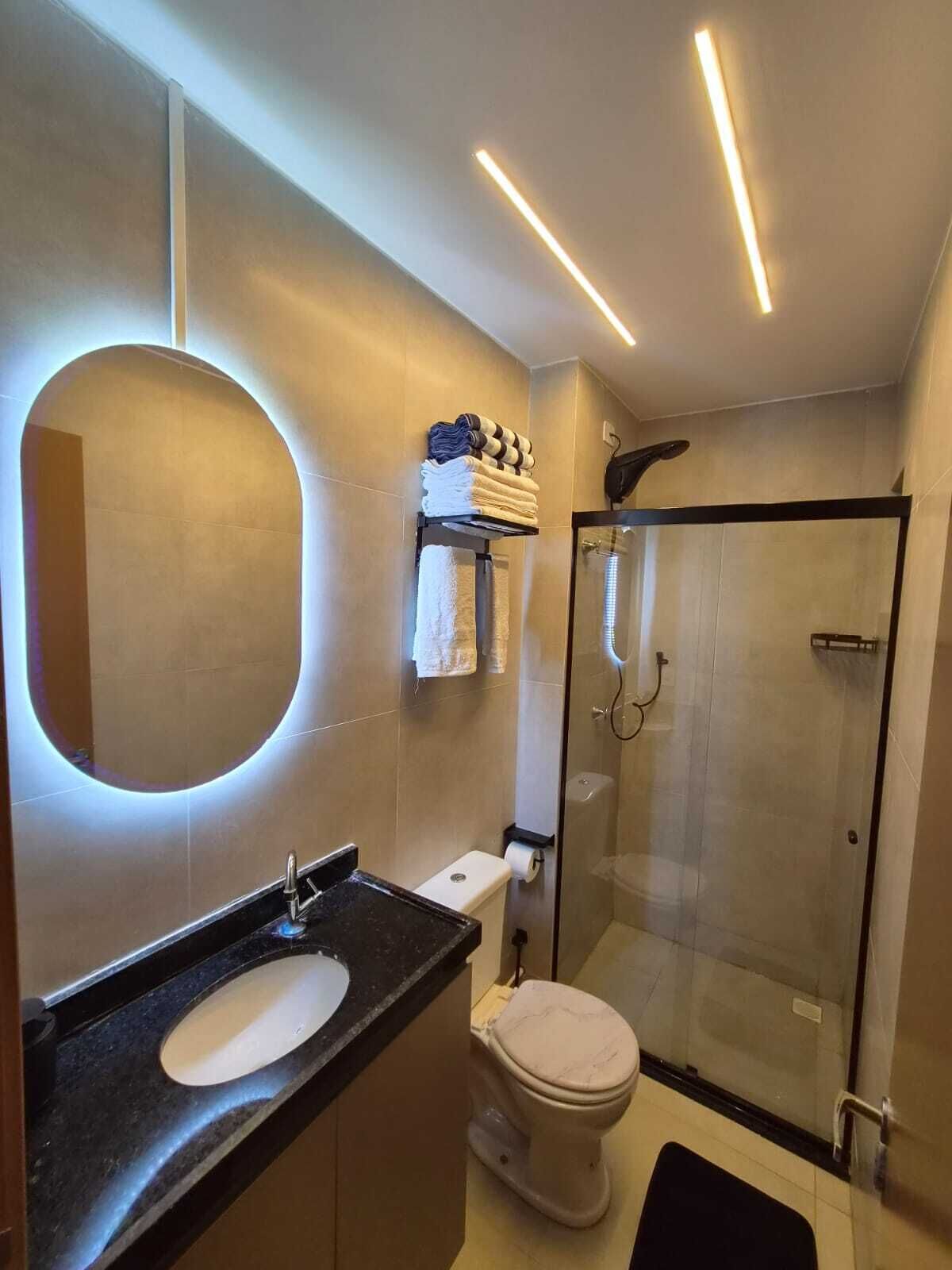 Chuveiro, secador de cabelo, toalhas de banho, papel higiênico