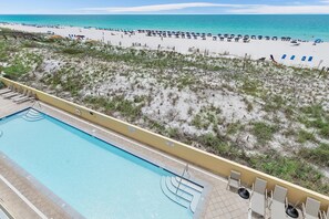 Ein Pool neben einem Strand mit freiem Blick auf den Ozean.