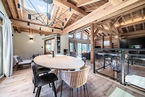 Ein geräumiges Zimmer mit einem großen runden Tisch, modernen Stühlen und einer Glastrennwand.