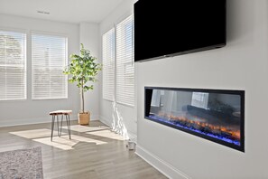 Ein modernes Wohnzimmer mit einem Flachbildfernseher, einem großen Aquarium und einer Topfpflanze.
