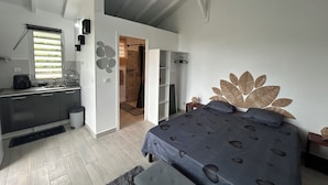 Un dormitorio con cama, baño y kitchenette.