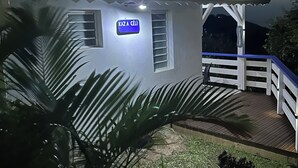 Una casa con un porche, un cartel que dice 'KAZA CÉLI' y vista al cielo.