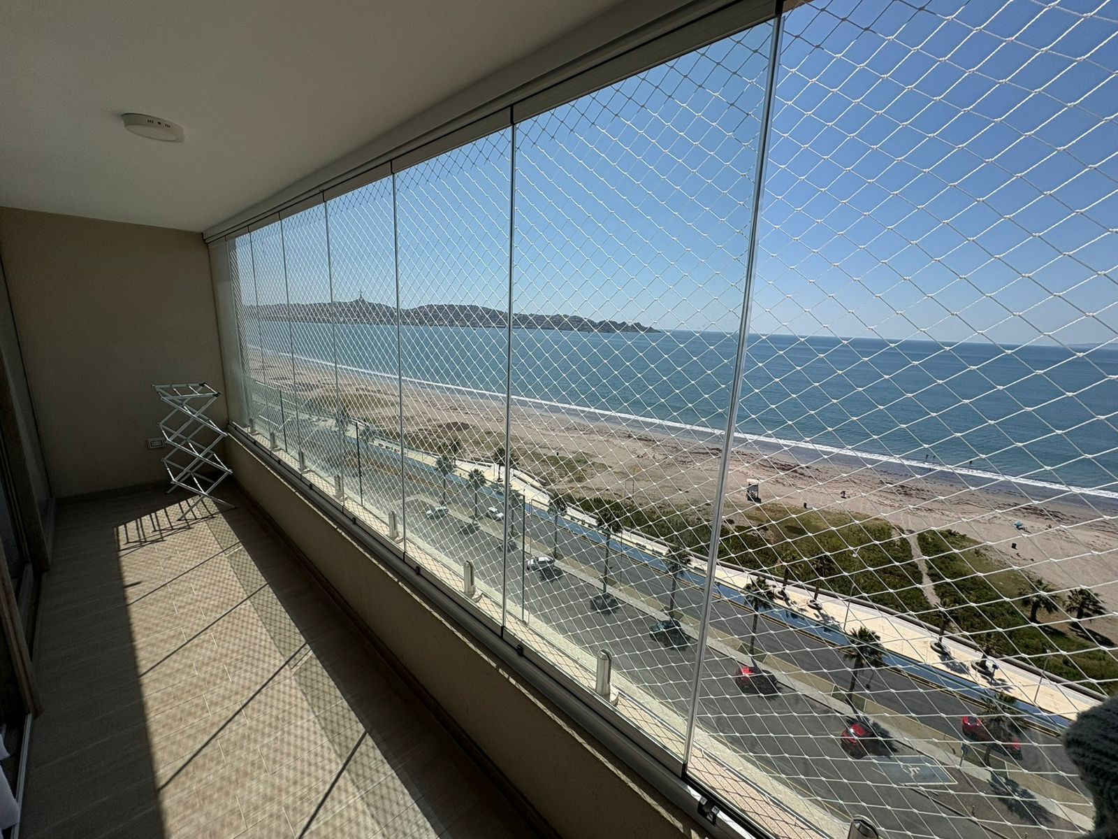 A balcony with a view of the beach and ocean.