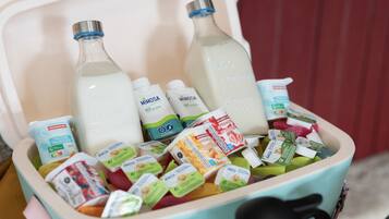 Un refrigerador lleno de botellas de leche, recipientes de yogur y diversos alimentos envasados.