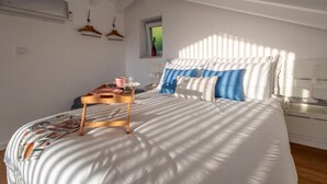 A bedroom with a bed, bedside table, and a window.