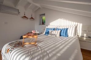 Ein Schlafzimmer mit Bett, Nachttisch und Fenster.