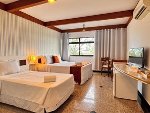 A hotel room with two beds, a desk with a computer, a chair, and a window with curtains. - Villa Nautilus by Be Happy (Fortaleza)