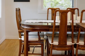 A dining table with chairs, a white tablecloth, and candles.