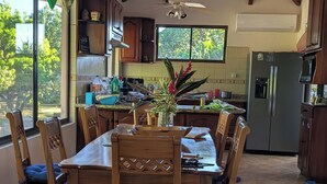 A spacious kitchen with a dining area, wooden furniture, a ceiling fan, and a large window. - Walk to Secluded Playa Azul, Private Pool, 4 Ocean-view Bedrooms, sleeps 8 (Guanacaste Province)
