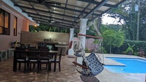 An outdoor patio with a dining table, chairs, a grill, and a hanging hammock. - Walk to Secluded Playa Azul, Private Pool, 4 Ocean-view Bedrooms, sleeps 8 (Guanacaste Province)