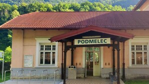 A building with a sign reading 'PODMELEC' and a checkered floor pattern. - Unique Slovene alpine house, within the Soca Valley, close to Most na Soci. (Tolmin)
