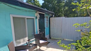 Une terrasse avec des meubles en osier et une porte.
