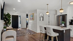 A modern kitchen with a central island, bar stools, pendant lighting, and a large refrigerator. - Top-Rated Premier Modern Getaway (Petersburg)