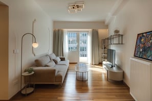 Ein modernes Wohnzimmer mit Sofa, Couchtisch und Fernseher.