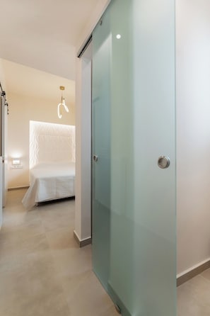 Ein Schlafzimmer mit Bett, einer Schiebetür und einer Leuchte.