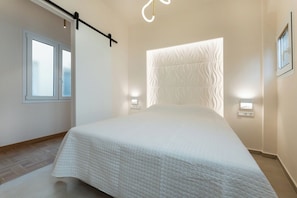 Ein modernes Schlafzimmer mit einem großen Bett, einem Fenster und Wandleuchten.