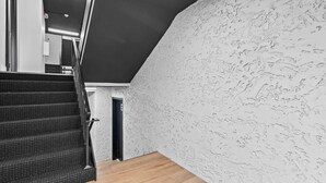 A staircase with a textured wall and a wooden floor. - Newly Renovated Unit in Central Spfld! #203 (Springfield)