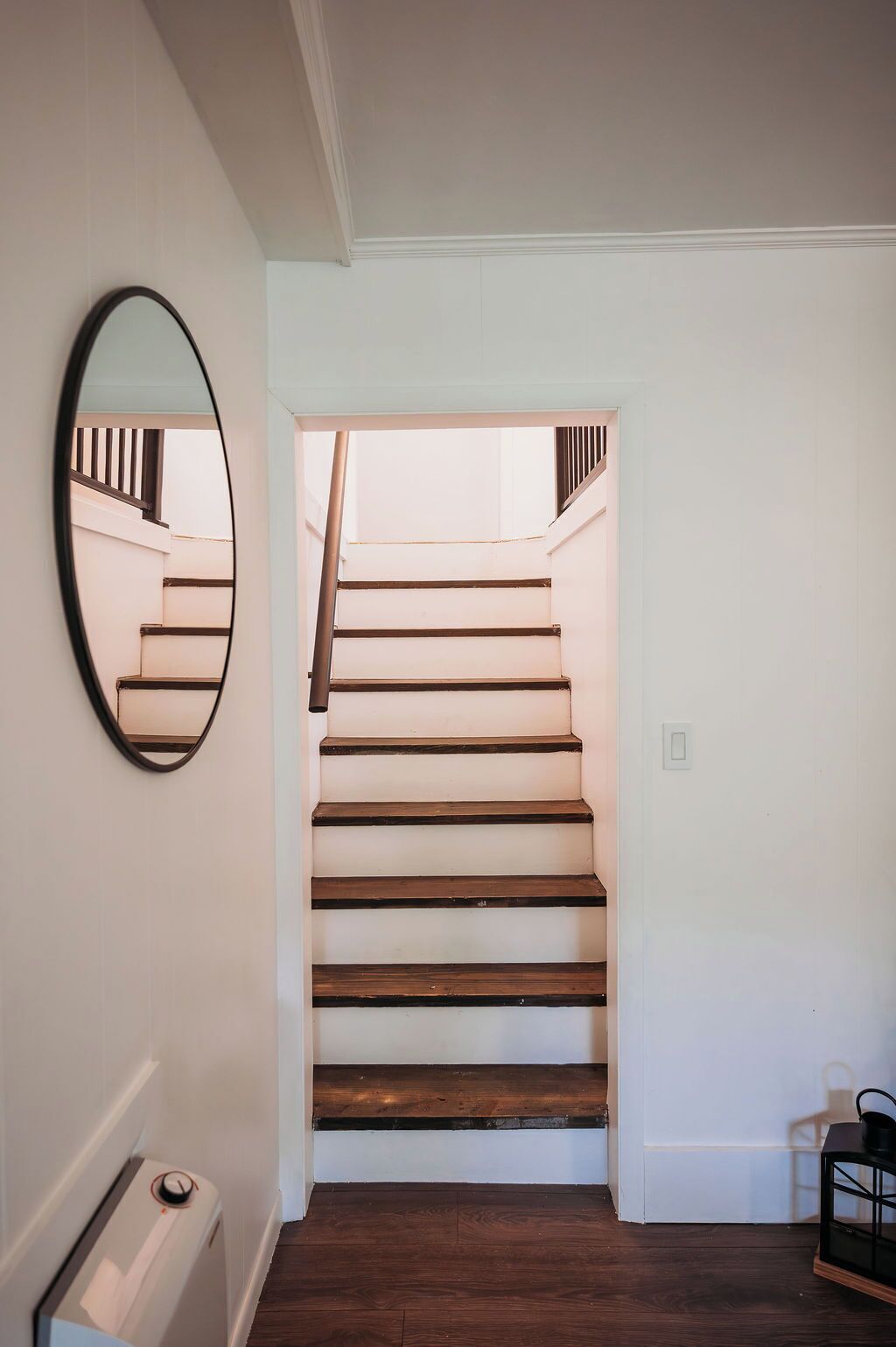 A staircase with wooden steps and a white wall.