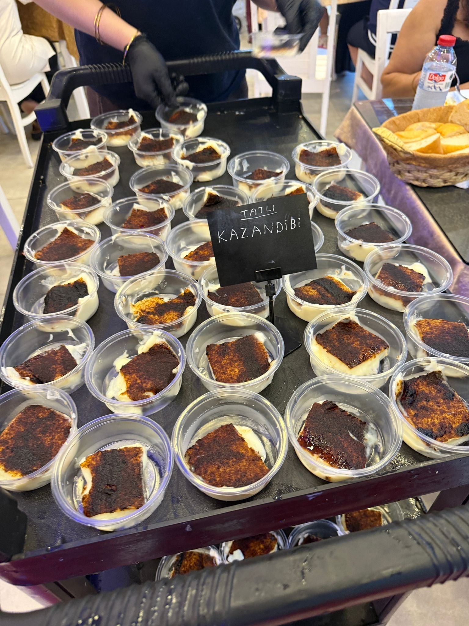 A tray of dessert cups labeled 'ITALIA KAZANDIBI' on a table.