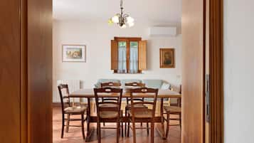 A dining area with a wooden table, chairs, and a chandelier.