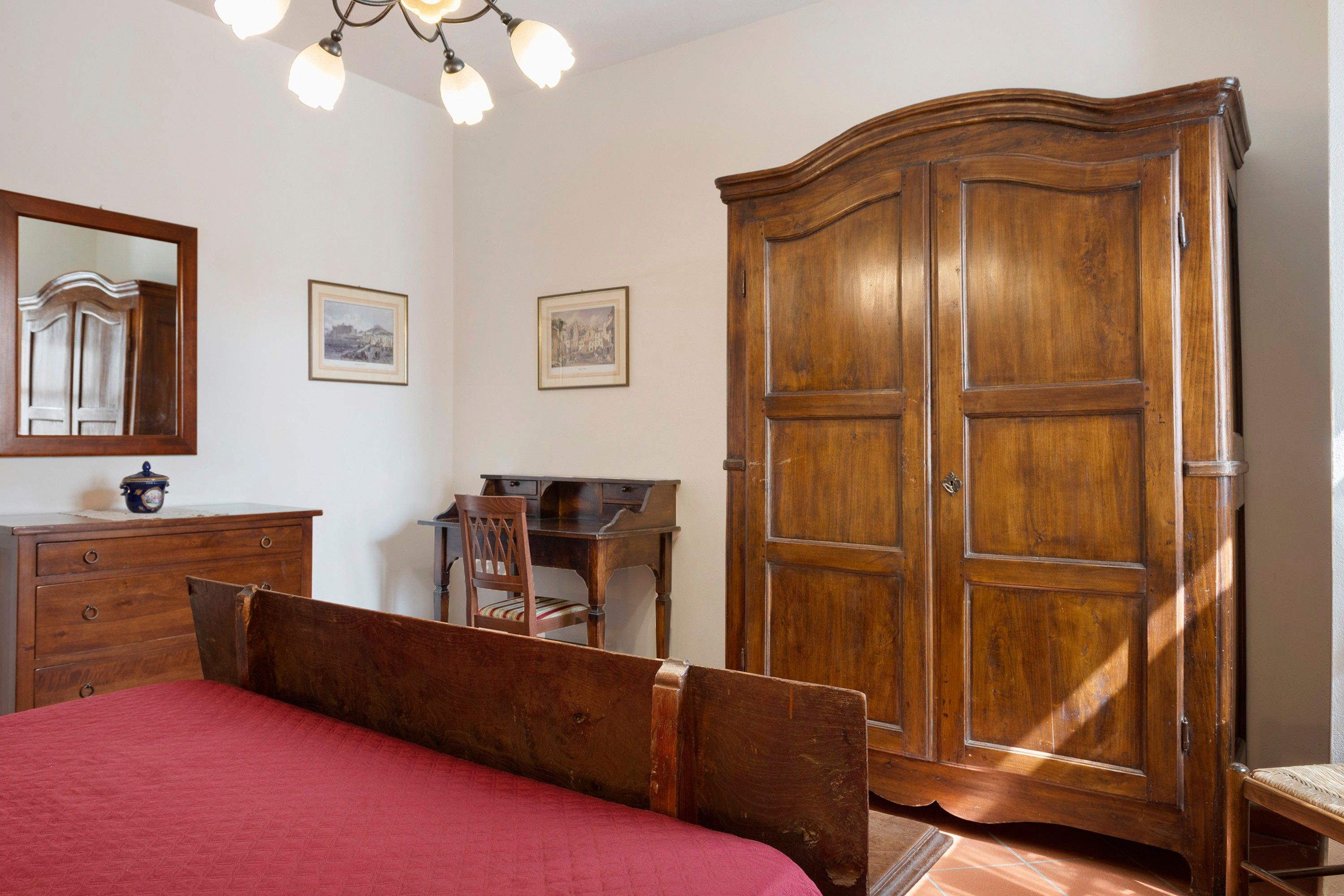 Un dormitorio con cama de madera, cómoda, escritorio y armario.