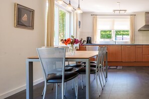 Ein Essbereich mit Tisch, Stühlen und einem Blumenstrauß.