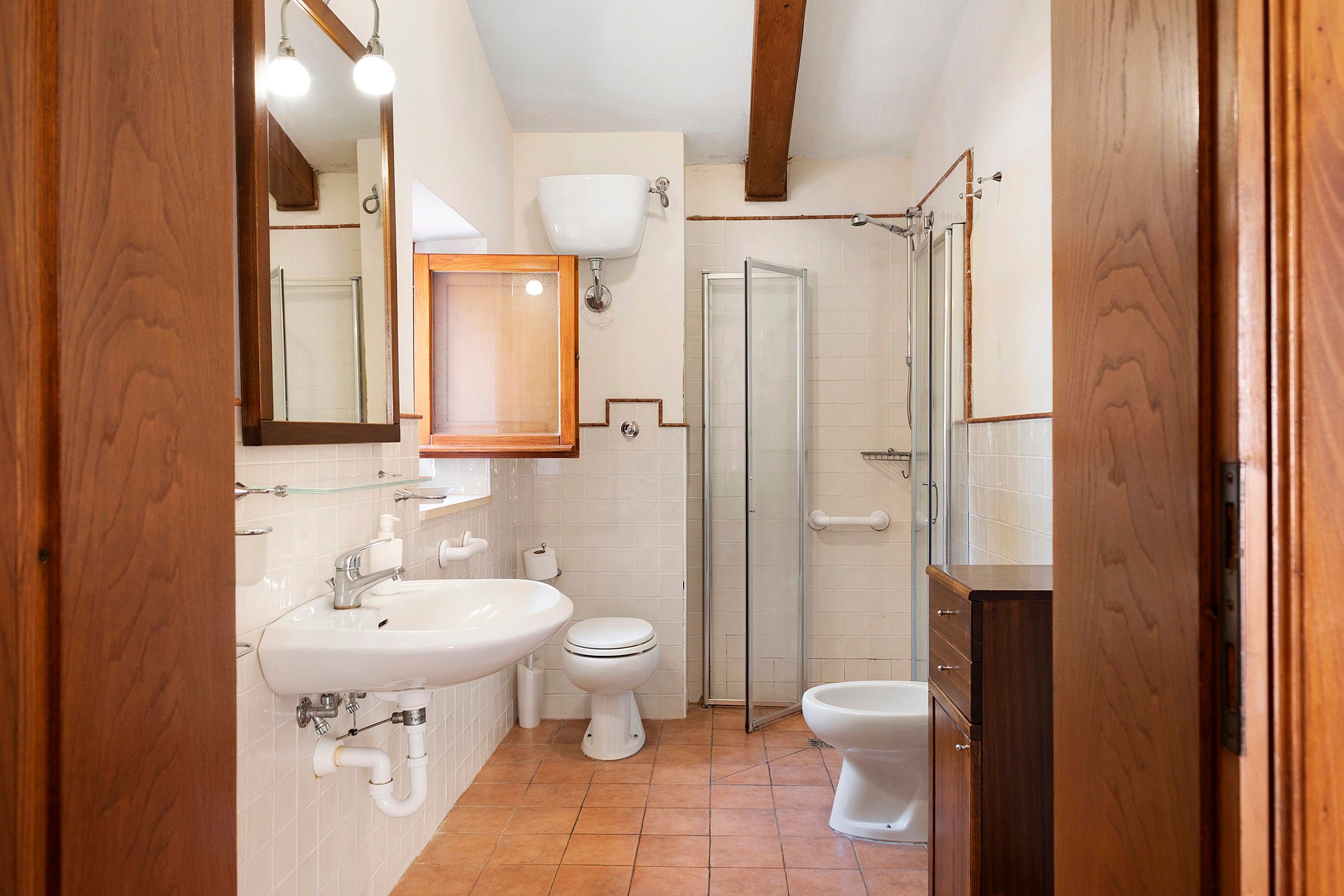 Un baño con lavamanos, inodoro y ducha.