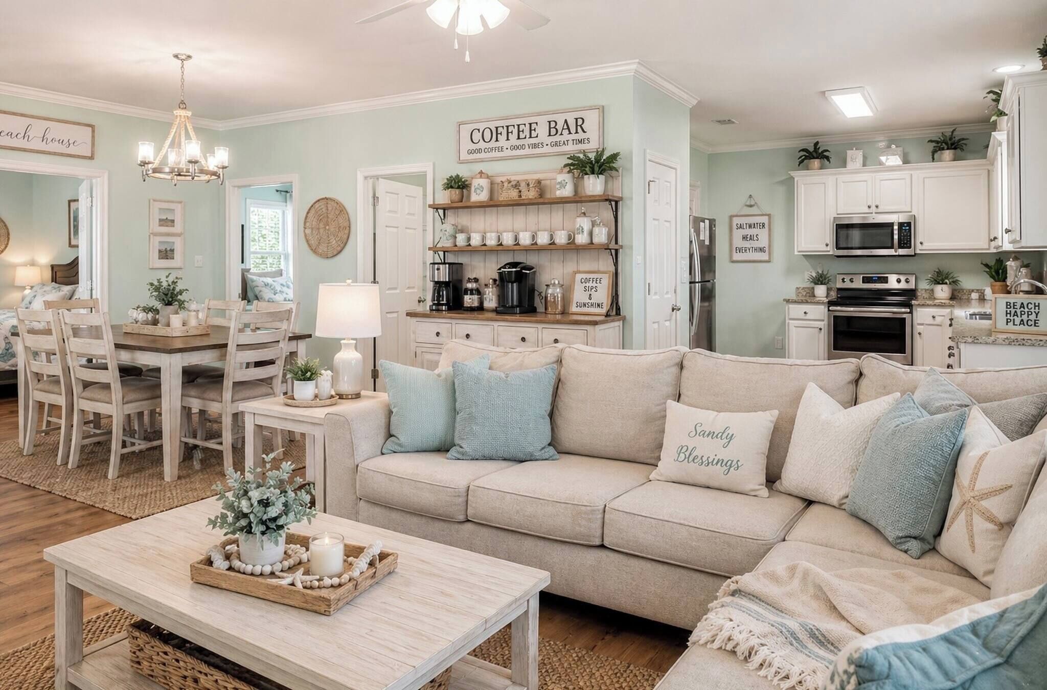 Una sala de estar acogedora con un sofá color beige, una barra para café y una zona de comedor con mesa y sillas de madera.
