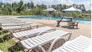 Area piscina con lettini, tavolo da picnic e piscina con acqua cristallina.